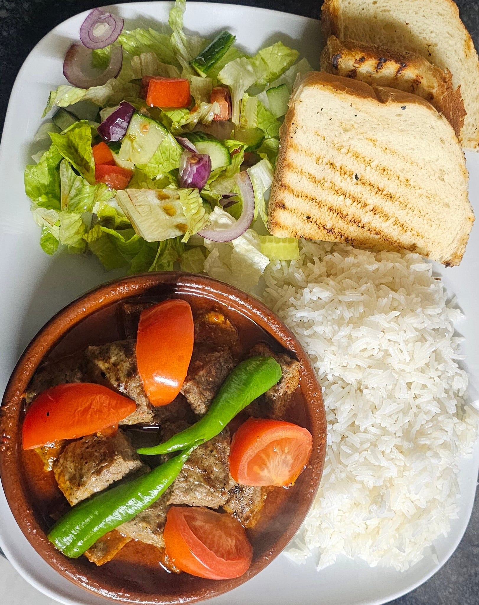 Lamb güveç clay-pot stew with rice and salad