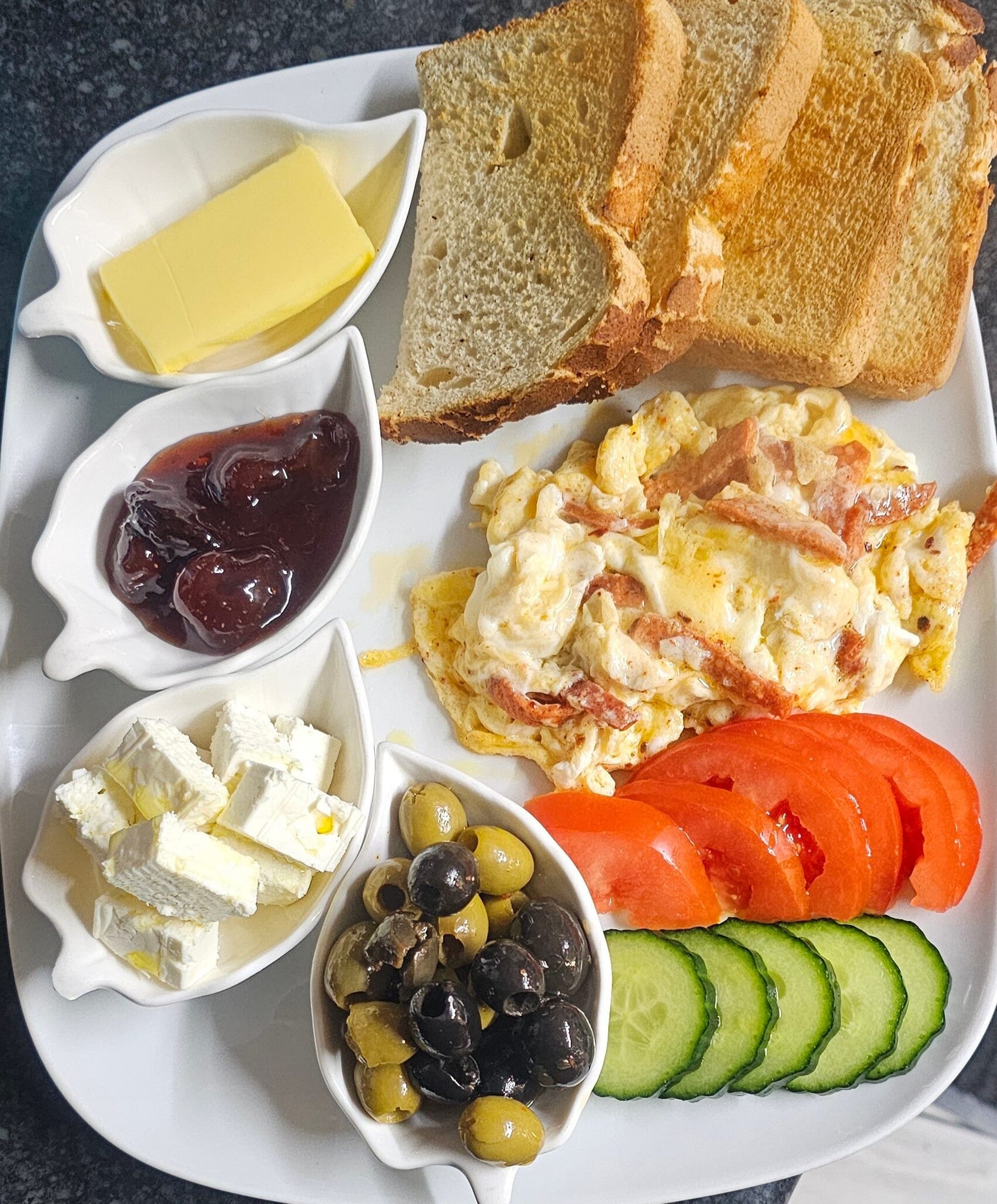 A Turkish breakfast platter with feta, olives, eggs and sucuk